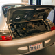A 2003 Porsche 911 has its engine decklid open.